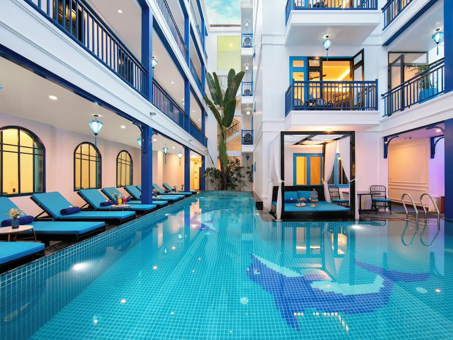 Una piscina al aire libre, sombrillas, tumbonas
