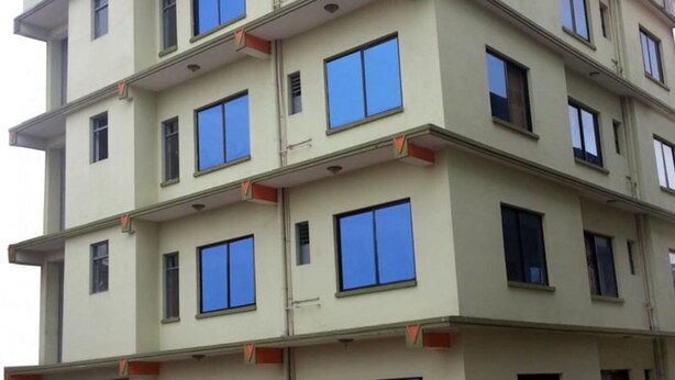 A multi-story building with a uniform facade, featuring evenly spaced windows and balconies. - Pashupati Plaza (Kathmandu)