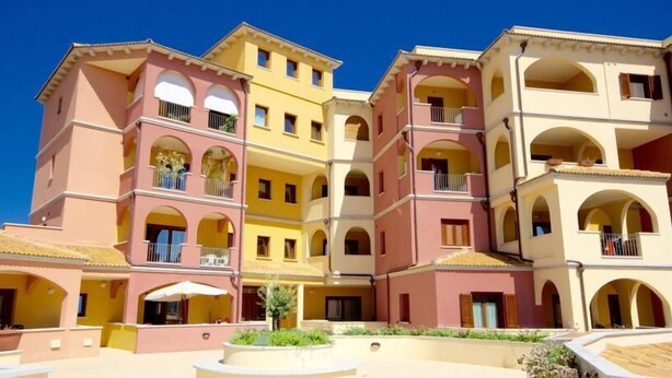 A multi-story hotel with balconies and a central courtyard. - Park 20 Guesthouse (Olbia)
