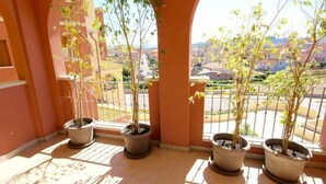 A balcony with potted plants and a view of a cityscape. - Park 20 Guesthouse (Olbia)