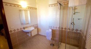 Une salle de bain avec un lavabo, un miroir et une douche.