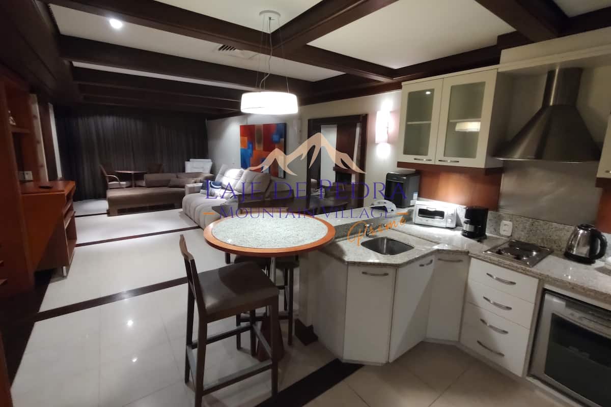 Una cocina moderna con una isla central, electrodomésticos integrados y un comedor con una mesa redonda y sillas.