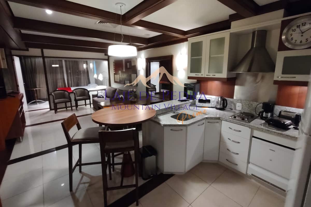 Una cocina moderna con armarios blancos, horno integrado y un reloj en la pared.