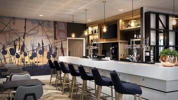 Un área de bar moderna con una barra alargada, varios taburetes y una variedad de botellas y vasos.