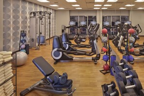 Un gimnasio con equipo de ejercicio, un espejo y suelo de madera.