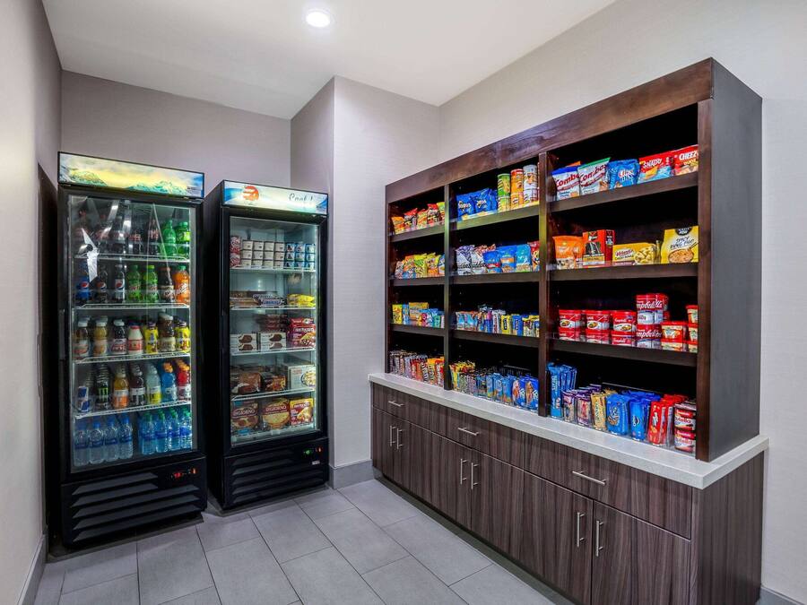 Two beverage vending machines and a pantry stocked with snacks and beverages.