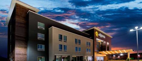A La Quinta hotel with a modern design, featuring a flat roof, multiple windows, and a parking lot.