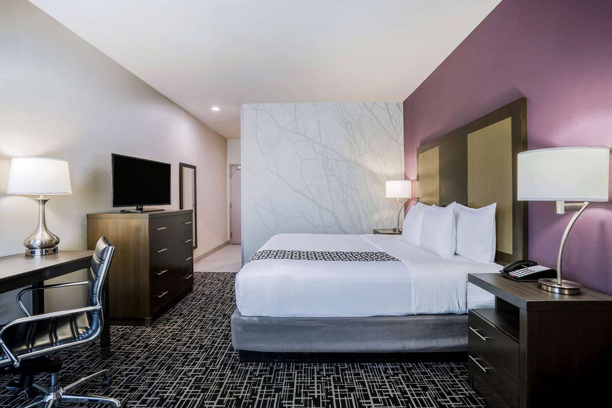 Une chambre d’hôtel équipée d’un lit, d’un bureau, d’une chaise et d’un téléviseur.