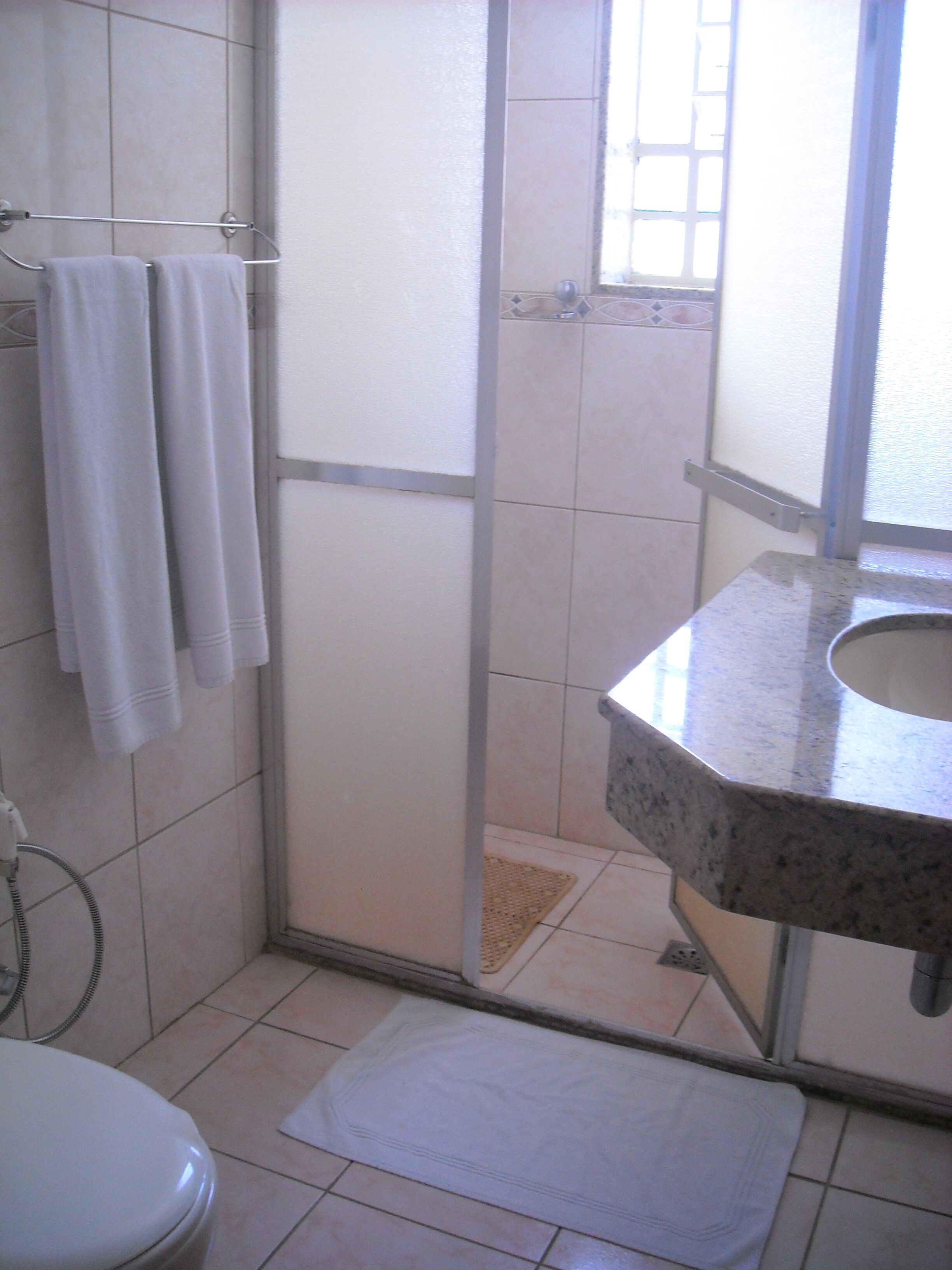 A bathroom with a shower, a toilet, and a sink.