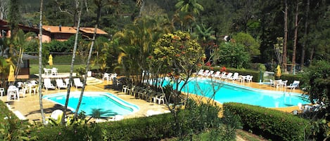 Una piscina al aire libre, sombrillas, tumbonas