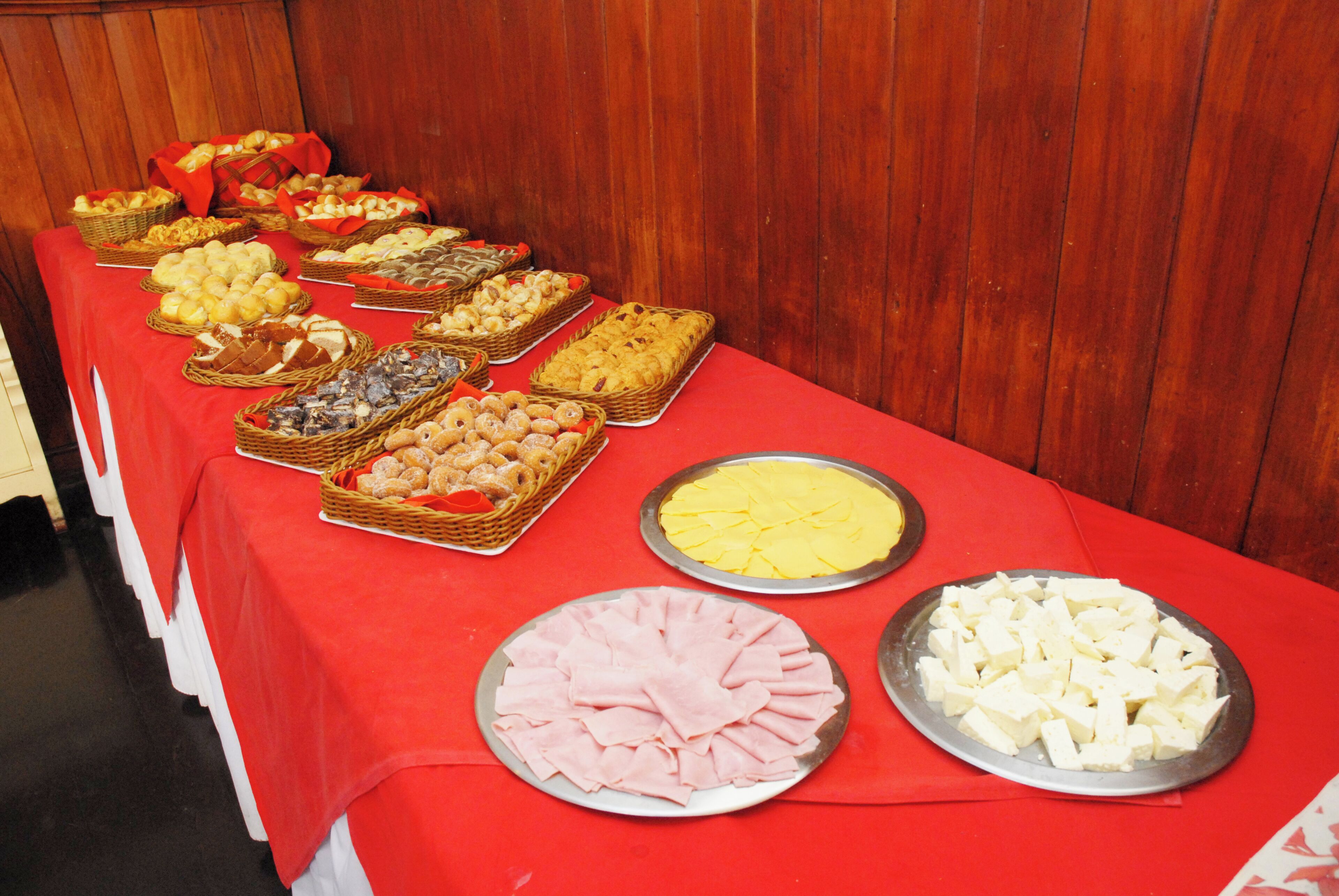 A buffet table with various food items including pastries, meats, and cheeses.