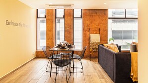 A dining area with a table set for four, two chairs, and a sofa with cushions. - Grand Chapultepec Residencial (Mexico City)