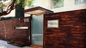 Una entrada moderna de edificio con fachada de madera, puerta de vidrio y un letrero que indica 'Lamartine 619'.