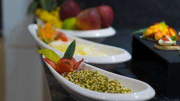 A row of white dishes with various food items and garnishes.