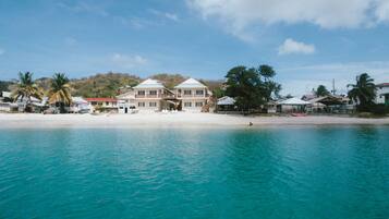 Aan het strand, wit zand, ligstoelen aan het strand, strandlakens