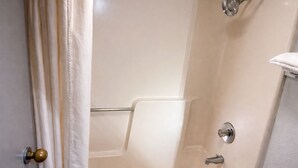 Un baño con bañera, ducha y un perchero para toallas.