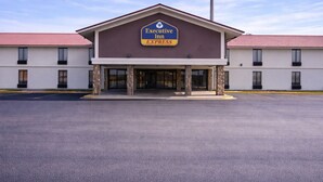 Edificio de Executive Inn Express con techo plano, pilares de piedra y cielo despejado.