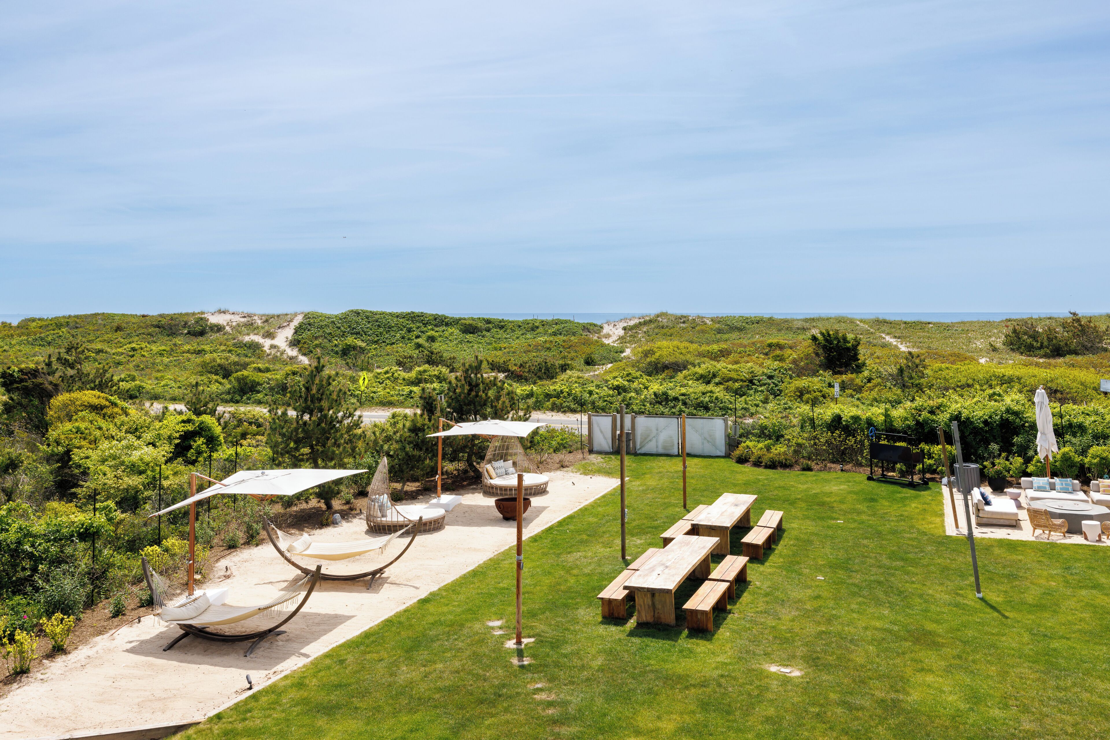 Eine Terrasse mit Hängematten, einem Grillplatz und Blick auf die umliegende Landschaft.