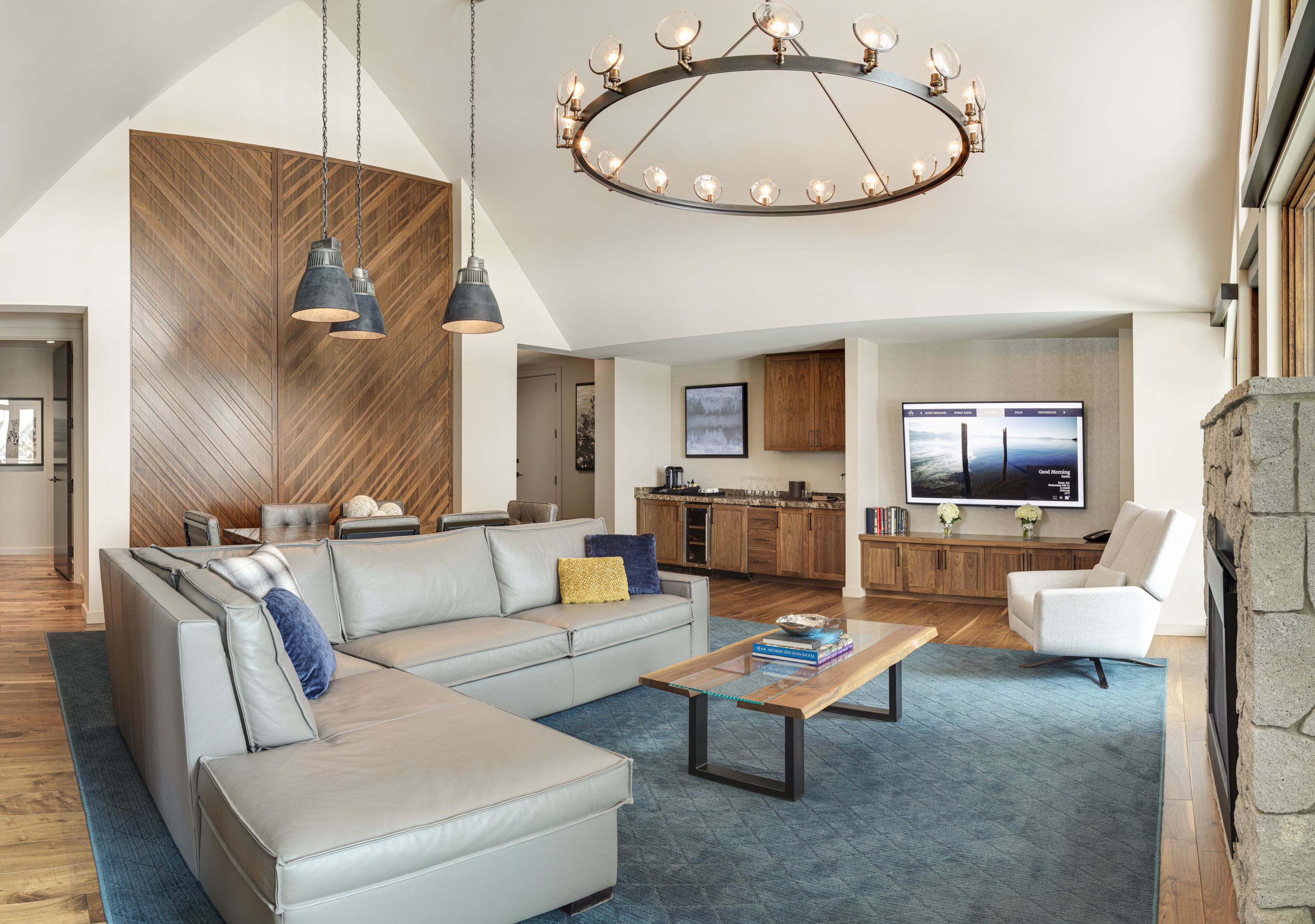 A modern living room with a sectional sofa, a coffee table, and a fireplace.