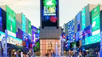 A modern building with a large digital billboard displaying "BLIND RUTH CITY".