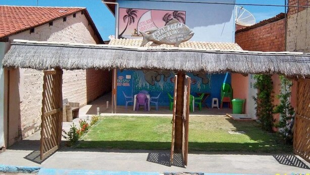 Una construcción con techo de paja y un letrero que indica un negocio llamado "Vovo Elias".