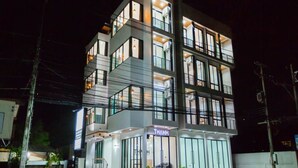 A multi-story building with a modern design, featuring balconies and large windows.