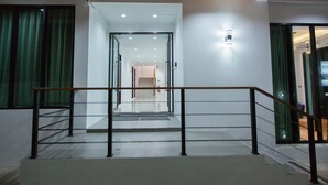 A modern interior with a staircase, wooden ceiling, and glass doors leading to another room.