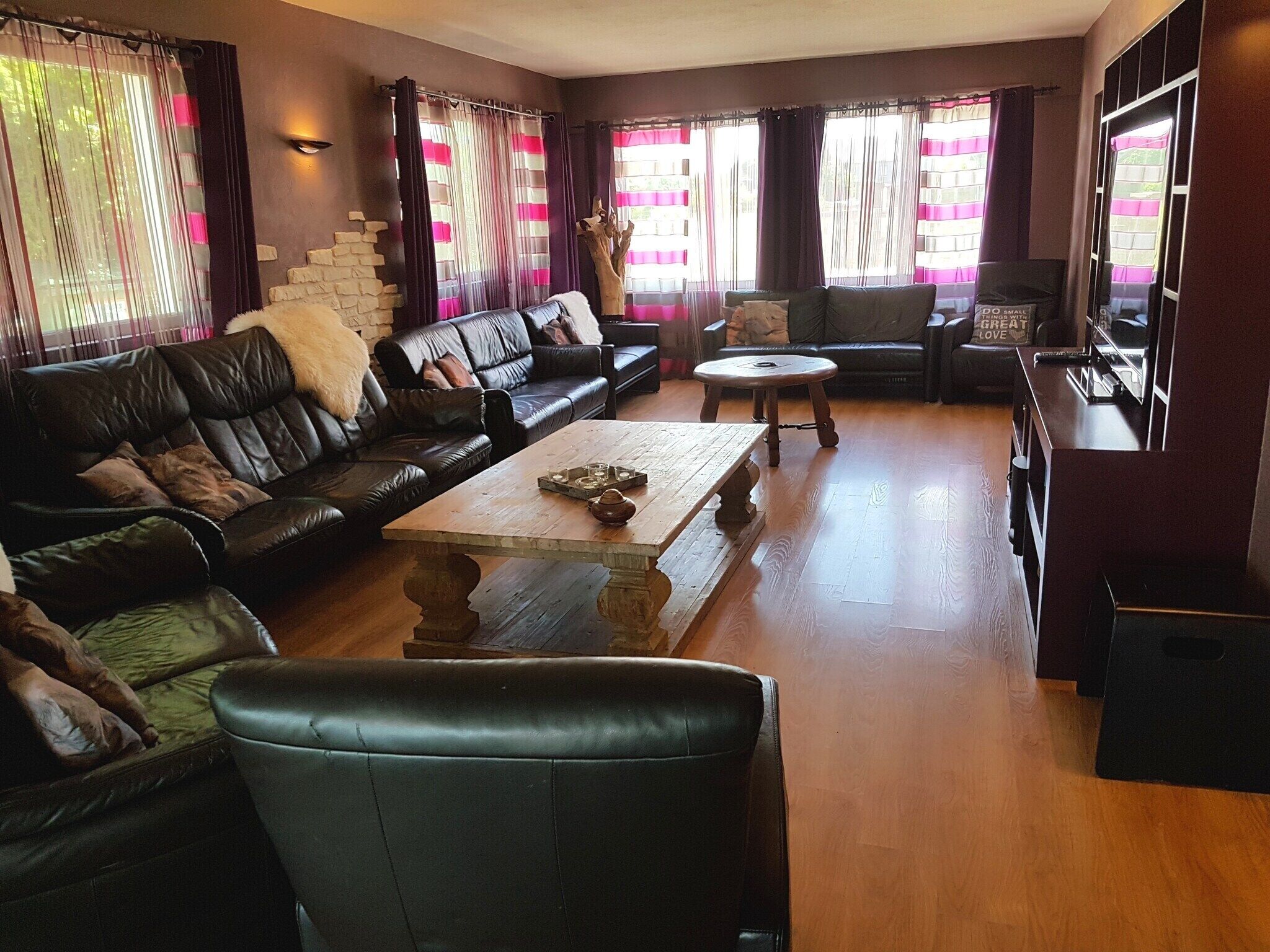 Een woonkamer met een bank, salontafel en een stenen muur.