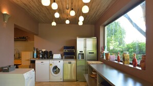 Une cuisine moderne équipée d’un lave-linge, d’un réfrigérateur et d’une machine à café.