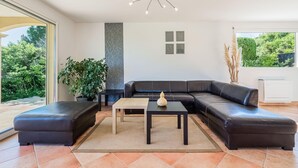 Ein modernes Wohnzimmer mit einem Ecksofa, einem Couchtisch und einem Topfpflanzen.