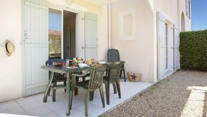 A dining area with a table set for four, chairs, and a basket of bread. - Coastal Stay for Groups (Saint-Aygulf)