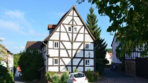 A traditional half-timbered house with a car parked in front. - Traditionelles Ferienhaus in Hessen mit Garten (Willingshausen)