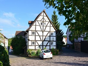 A traditional half-timbered house with a car parked in front. - Traditionelles Ferienhaus in Hessen mit Garten (Willingshausen)