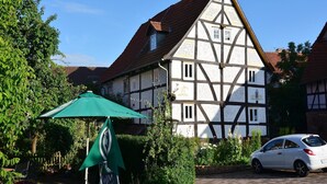 A traditional half-timbered house with a car parked in front. - Traditionelles Ferienhaus in Hessen mit Garten (Willingshausen)