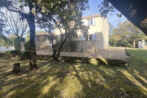 A building with a stone staircase leading to a door, surrounded by trees and a grassy area. - Inviting Villa with Swimming Pool (SAUMANE-DE-VAUCLUSE)