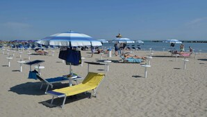 Une plage avec de nombreux transats et parasols.