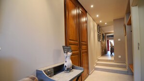 A hallway with a wooden door, a small table with a ceramic pig, and a sign that reads "Welcome". - Holiday Home in Ardennes near Chimay Abbey (Nismes Viroinval)