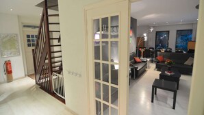 Ein moderner Wohnbereich mit Treppe, einer Sofagruppe und einem Essbereich.