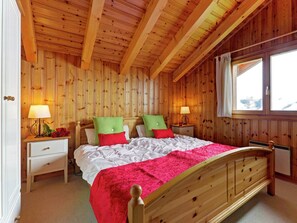 Relax in this inviting bedroom with a large bed, two bedside tables, and a window with curtains.
