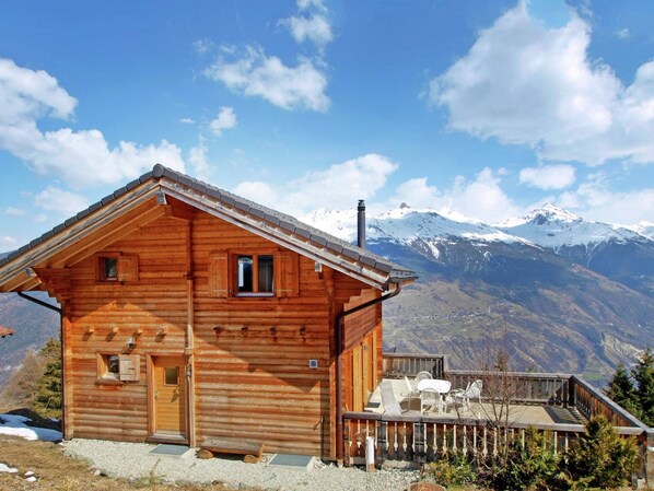 Set against the majestic mountains, this cabin features a cozy porch with outdoor seating.