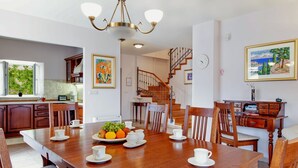 A spacious dining area with a wooden table set for breakfast, a staircase, and a kitchen in the background. - Villa in Selca with Pool near Adriatic Sea (Sumartin)