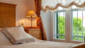 A bedroom with a bed, a nightstand, a lamp, and a window with a view of greenery. - Villa in Selca with Pool near Adriatic Sea (Sumartin)