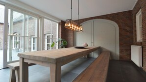 Ein modernes Interieur mit einem Holztisch, einer Bank und einer hängenden Leuchte.