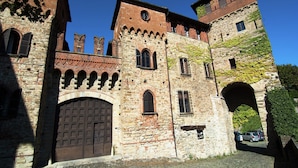 Un bâtiment historique en pierre, doté d’arcades au niveau des entrées, d’une grande porte centrale et de nombreuses fenêtres.