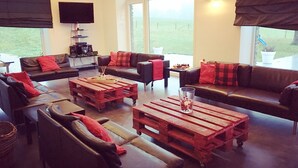 Una sala de estar con un amplio ventanal, un televisor de pantalla plana y una mesa de centro.
