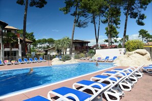 A swimming pool with lounge chairs and a building in the background.
