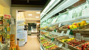 Una tienda de comestibles con una sección de productos refrigerados a la izquierda y una sección de frutas y verduras a la derecha.