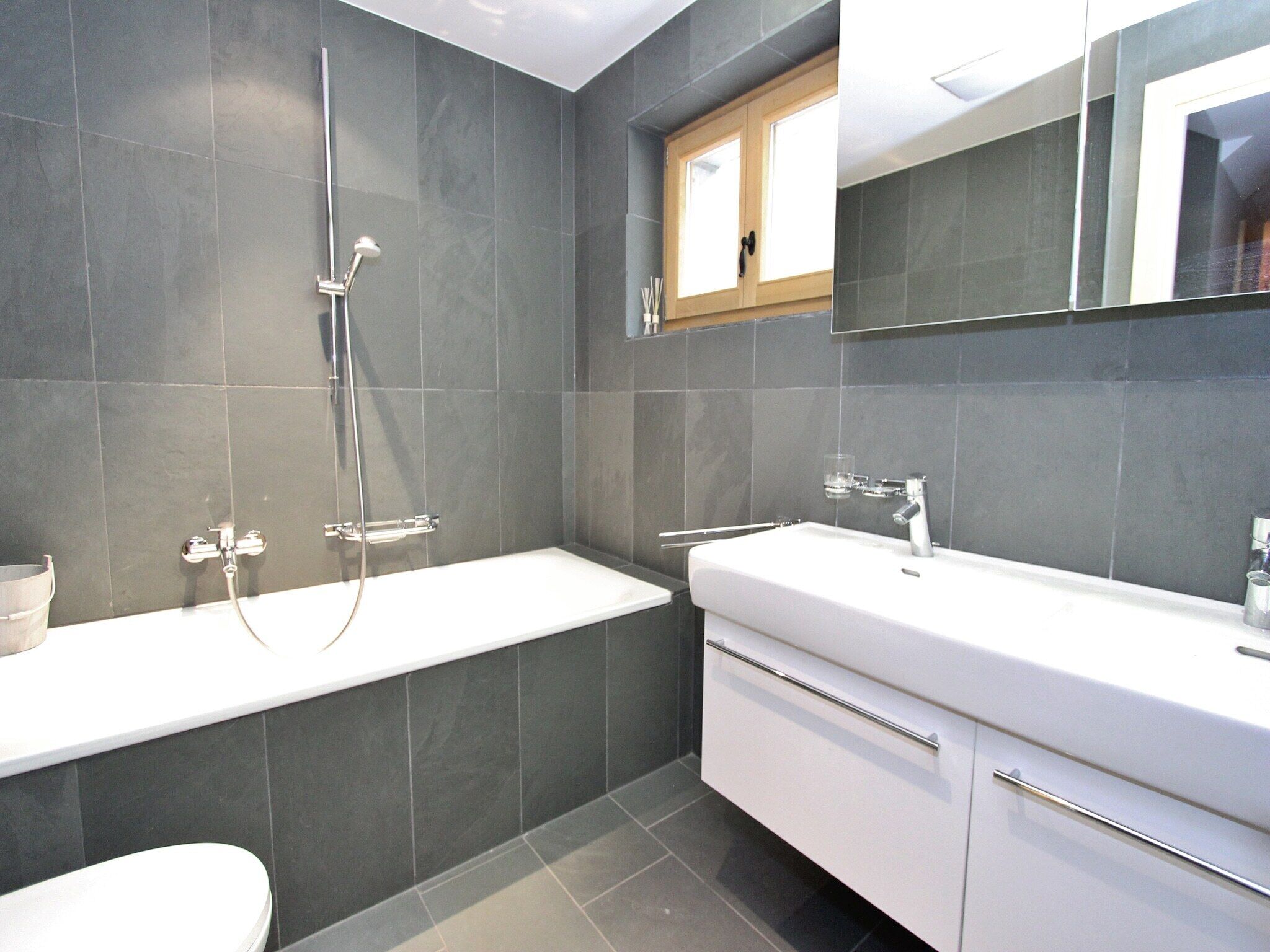 A modern bathroom with a bathtub, a sink, and a toilet.