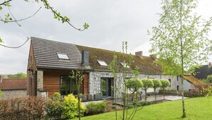 A modern house with a stone facade, wooden accents, and a well-maintained lawn.