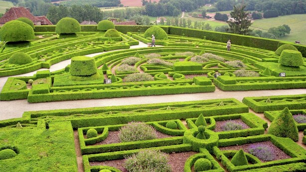 A meticulously landscaped garden with geometric patterns and topiary shapes. - Chalet in picturesque medieval village (Segur-Le-Chateau)